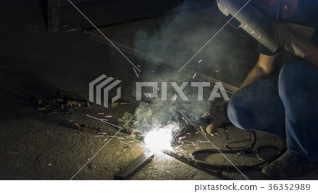 worker welding metal, focus on flash light 36352989
