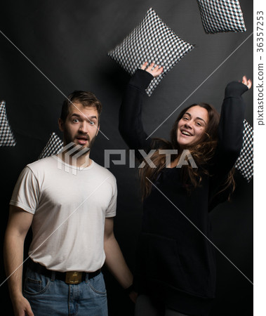 cheerful young couple throwing pillows 36357253