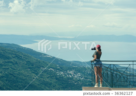 female with camera stands on the balcony 36362127