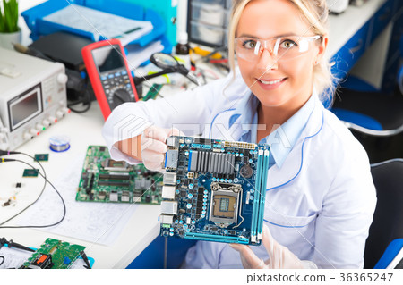 Female electronic engineer holding computer motherboard in hands 36365247