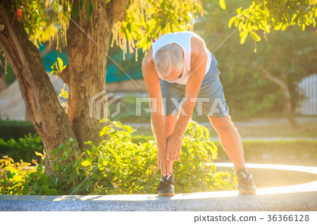 Old Man Does Exercises Bends Body to Foot 36366128