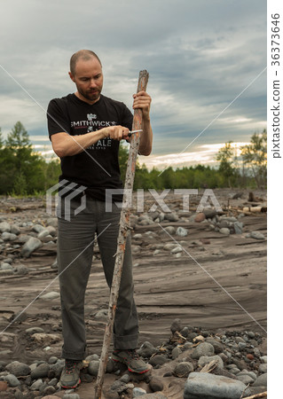 Tourist is scolding a wooden stick on the shore of Tourist is scolding a wooden stick on the shore of 36373646