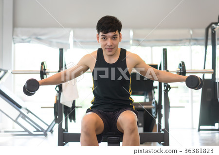 Handsome muscular man working out with dumbbells  36381823
