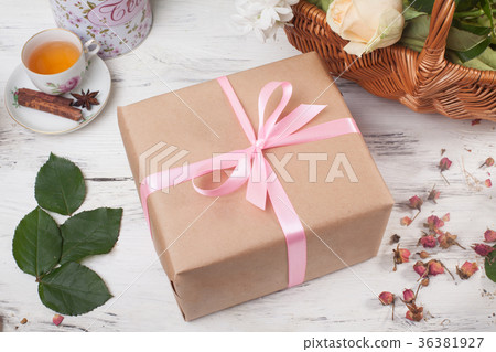 Gift box in kraft paper with satin ribbon on a Gift box in kraft paper with satin ribbon on a 36381927