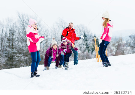 Family with kids having snowball fight in winter 36383754