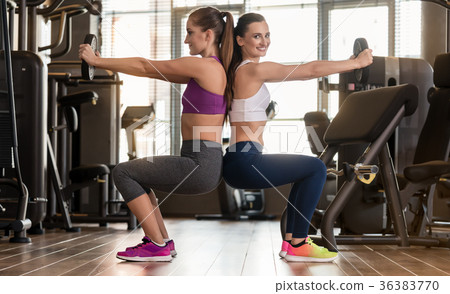 Two young women exercising together back to back 36383770