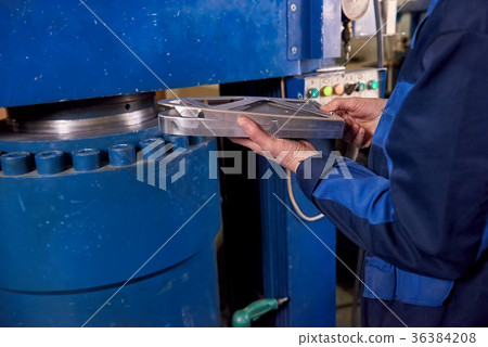 Hands holding metal part. 36384208