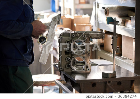 Worker is connecting one metal detail to another. Worker is connecting one metal detail to another. 36384274