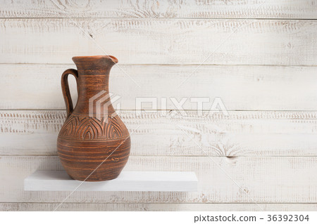 clay jug at shelf on white wooden background clay jug at shelf on white wooden background 36392304