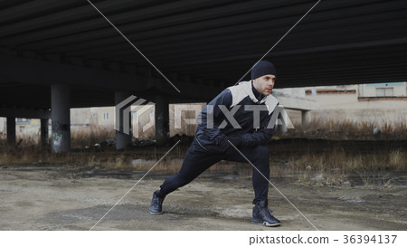 Attractive man runner doing stretching exercise Attractive man runner doing stretching exercise 36394137