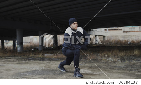 Attractive man runner doing stretching exercise Attractive man runner doing stretching exercise 36394138