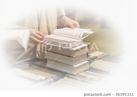 Close-up of woman's hands with pile of books Close-up of woman's hands with pile of books 36395331