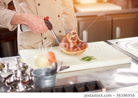 Processing of lamb shank with torch burner. Processing of lamb shank with torch burner. 36396956