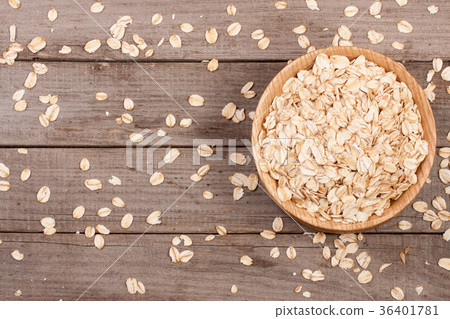 Oat flakes in a wooden bowl on old wooden 36401781