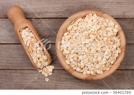 Oat flakes in a wooden bowl with a scoop on an old Oat flakes in a wooden bowl with a scoop on an old 36401789