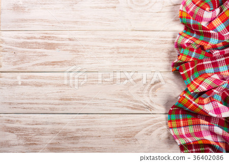 Red checkered tablecloth on a light wooden table 36402086