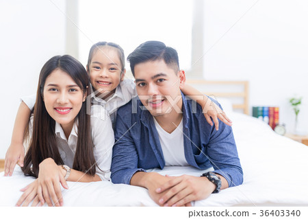 Happy asian family lying on a bed 36403340