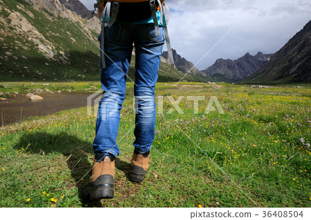 young backpacking woman hiking in mountains 36408504