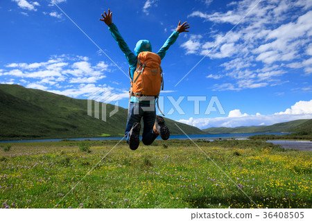 cheering young woman jumping on flowers and grass cheering young woman jumping on flowers and grass 36408505