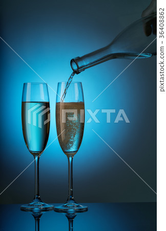 Two glasses with champagne pours from bottle 36408862
