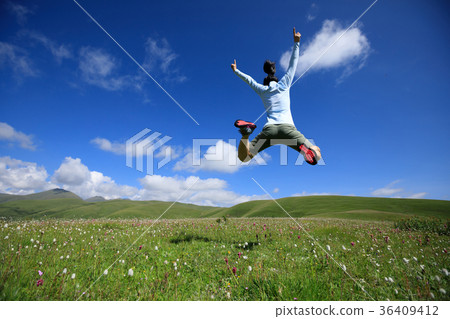 jumping woman have fun in a mountain peak meadow jumping woman have fun in a mountain peak meadow 36409412