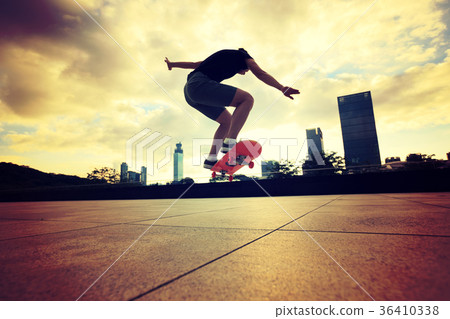 Woman practicing with skateboard at sunrise city Woman practicing with skateboard at sunrise city 36410338