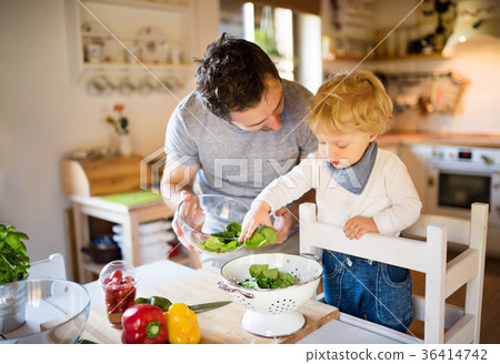 Young father with a toddler boy cooking. 36414742