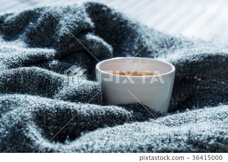 Close up white cup of tea wrapped in blanket Close up white cup of tea wrapped in blanket 36415000