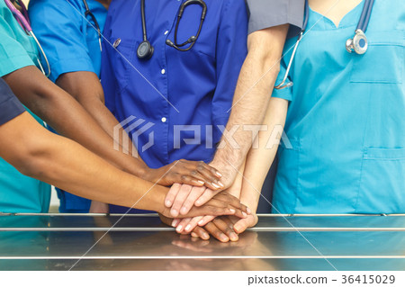 Multiracial team of young doctors stacking hands 36415029