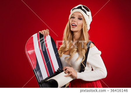 Woman with a snowboard, studio shoot. red background 36416146