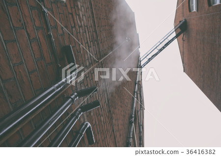 Facade of a brick house with pipes 36416382