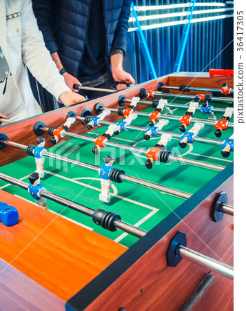 Cropped image of active people playing foosball Cropped image of active people playing foosball 36417305