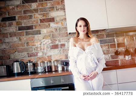 Beautiful redhead pregnant woman in white dress Beautiful redhead pregnant woman in white dress 36417778