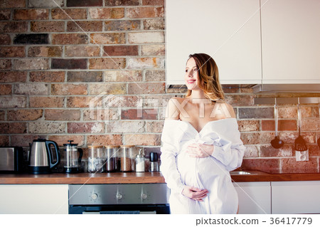 Beautiful redhead pregnant woman in white dress 36417779