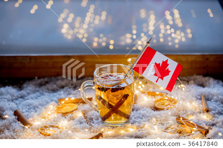 Cup of tea and flag of Canada on snow and fairy lights 36417840