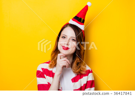 Portrait of young redhead woman in Santa Claus hat Portrait of young redhead woman in Santa Claus hat 36417841