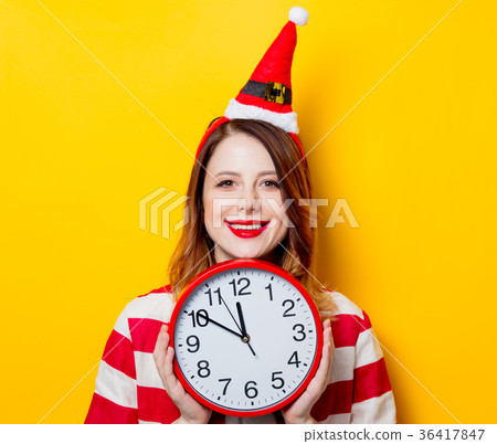 Smiling woman in Santa Claus hat with clock 36417847