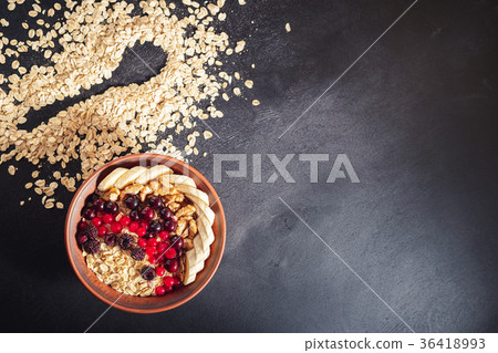Oatmeal in bowl with berries, bananas and walnuts Oatmeal in bowl with berries, bananas and walnuts 36418993