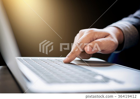Businessman working on laptop with hand typing a keyboard 36419412