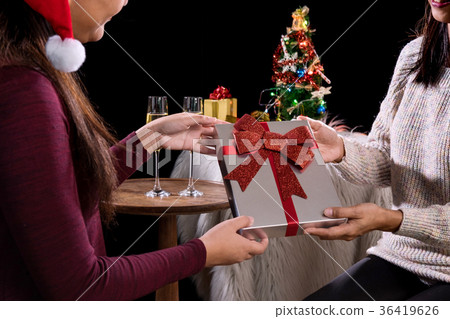 Beautiful two women holding gift boxes and two glasses with cham 36419626