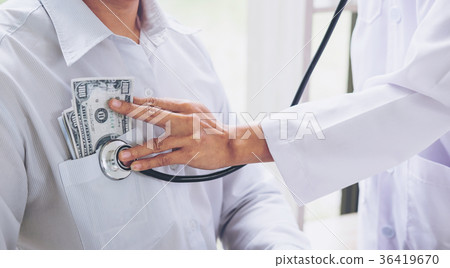 Doctor received corruption money, hand putting money in patient Doctor received corruption money, hand putting money in patient 36419670