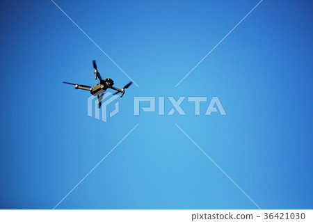 Flying drone with blue sky background 36421030