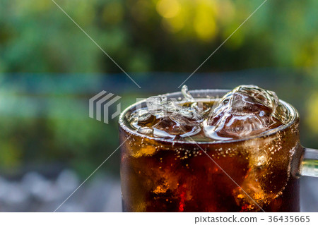 图库照片: close up the cool glass of cola with ice.
