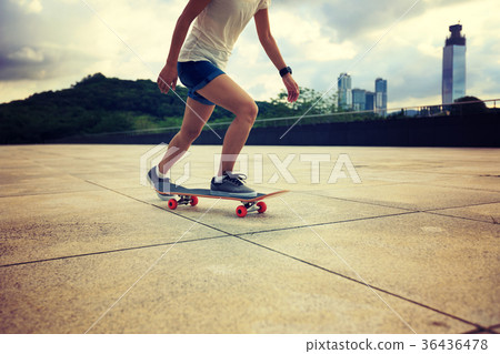 Woman practicing with skateboard at sunrise city Woman practicing with skateboard at sunrise city 36436478