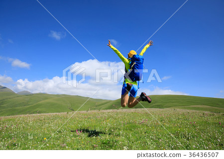 cheering woman jumping in grassland mountain top cheering woman jumping in grassland mountain top 36436507