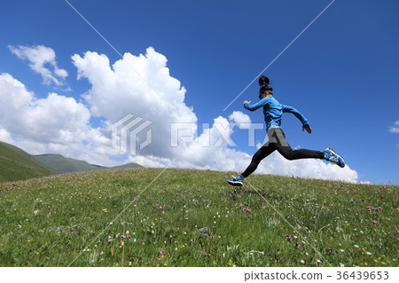 圖庫照片: fitness woman runner running jumping on grassland