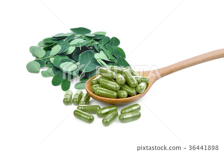 moringa oleifera capsule in wooden spoon with pile 36441898