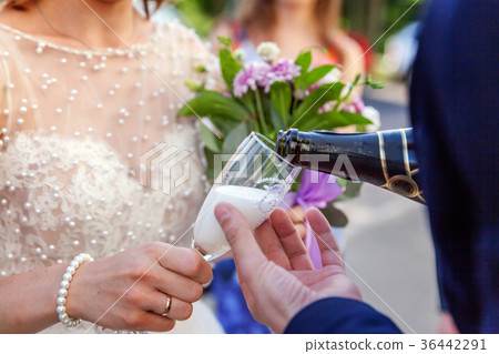 Champagne is poured into the glass Champagne is poured into the glass 36442291
