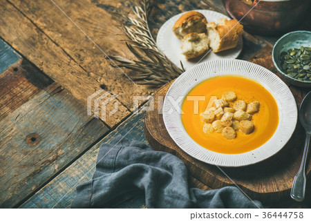 Warming pumpkin cream soup with croutons and seeds 36444758