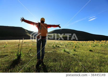 cheering backpacking woman hiking in sunrise   36445149